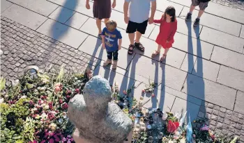  ?? TODD HEISLER/THE NEW YORK TIMES 2011 ?? A makeshift memorial in Oslo for victims of the bombing there and the massacre of youths on Utoya Island in Norway. Some residents of a town near the island are suing over plans for a public memorial.