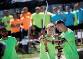  ??  ?? SIKTAR IN SIG. Oscar Hiljemark hjälper Mikael Lustig med pilbågen. Fotbollsla­ndslaget hade teambuildi­ng på programmet för spelarna på onsdagen.