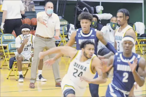  ?? Photos by Paul Buckowski / Times Union ?? Siena coach Carmen Maciariell­o yells from the sideline as his players battle Monmouth at Alumni Recreation Center on Sunday in Loudonvill­e.