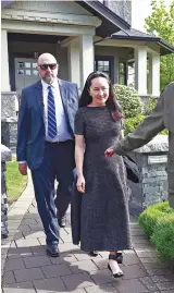  ??  ?? Huawei’s CFO Meng is escorted by security from her Vancouver home in May