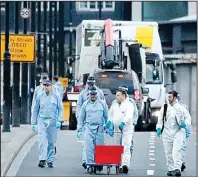  ?? AP/FRANK AUGSTEIN ?? A tow truck removes a van (rear) as forensic police collect evidence Sunday in the London Bridge area of London.