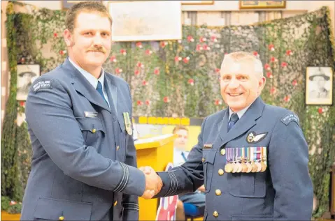  ?? PICTURE / SUPPLIED ?? Wing Commander Cannon (right) presents Flight Lieutenant Bryce Hackett with the NZ Cadet Forces Medal, recognisin­g his long service.