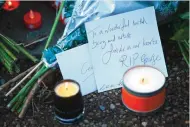  ??  ?? Messages and candles are seen among floral tributes outside the north London home of British singer George Michael yesterday, after news of the singer's death broke.