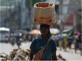  ?? /Foto: AFP ?? Un vendedor ambulante huye de la violencia de las pandillas en Puerto Príncipe.