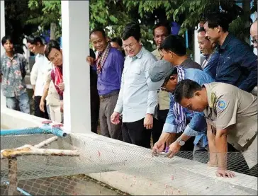  ?? MAFF ?? Agricultur­e minister Dith Tina and Stung Treng provincial governor Svay Sam Eang (on his right) visit the Mekong Aquatic Research and Production Centre in Sesan district last week.