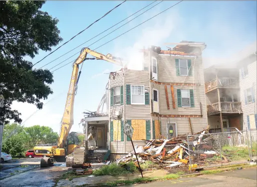  ?? Photos by Ernest A. Brown ?? Work crews from J.R. Vinagro Demolition were busy Friday demolishin­g one of two triple-deckers at 36-38 Burnside Ave. in Woonsocket. On Monday, the demolition of the building next door, at 46-48 Burnside Ave. will take place.