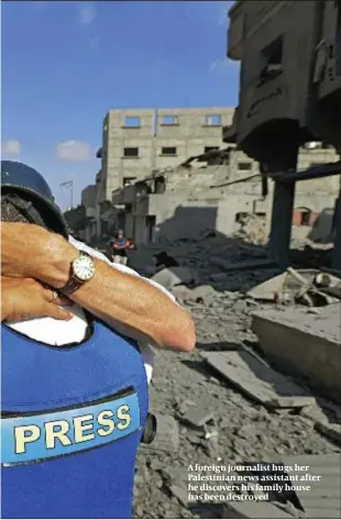  ?? PHOTO: AP ?? A foreign journalist hugs her Palestinia­n news assistant after he discovers his family house has been destroyed