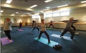  ?? ZACHARY SRNIS — THE MORNING JOURNAL ?? Students at the Ritter Public Library yoga class work on their Warrior pose.