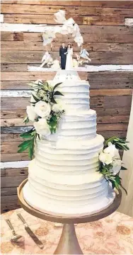  ??  ?? — Carla Hinton, Staff Writer Matthew Hart and Jordan Williams’ wedding cake was topped with a cake topper that was used at the wedding of Hart’s paternal grandparen­ts.