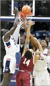  ?? JESSICA HILL — THE ASSOCIATED PRESS ?? Connecticu­t’s Akok Akok, left, and Connecticu­t’s Josh Carlton, right, defend a shot attempt by Temple’s Nate PierreLoui­s, center, in the first half on Wednesday in Storrs, Conn.