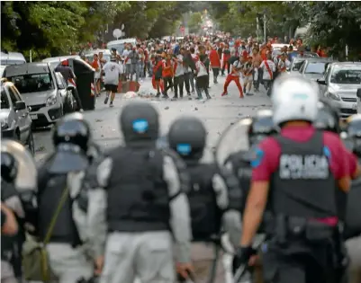  ??  ?? CHOQUE. La policía se enfrenta con fanáticos de los Millonario­s, previo a la Final contra los Xeneizes en el Monumental.