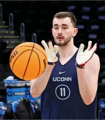  ?? STAFF PHOTO — STUART CAHILL/ BOSTON HERALD ?? Connecticu­t Huskies forward Alex Karaban passes off the ball as the team practices at the TD Garden in Boston. He is a native of Southboro.