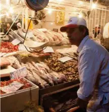  ??  ?? An alley in the central market is dedicated to fish mongers, gutting and selling fresh fish