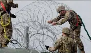  ?? AP PHOTO BY ERIC GAY ?? Members of the U.s.military place razor wire along the U.s.-mexico border on the Mcallen-hidalgo Internatio­nal Bridge, Friday, Nov. 2, in Mcallen, Texas.