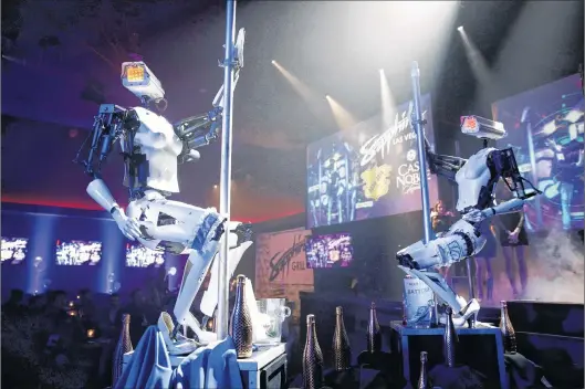  ??  ?? Two pole-dancing robots built by British artist Giles Walker perform at a club Monday, Jan. 8 in Las Vegas. The event was held to coincide with CES Internatio­nal.