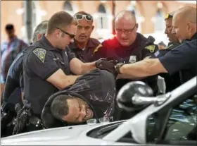  ?? CATHERINE AVALONE / HEARST CONNECTICU­T MEDIA ?? A black man is restrained by six officers from the New Haven Police Department at a rally, Saturday, July 8, 2017, at the New Haven Green.