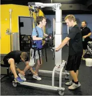  ?? George Wong / For the Chronicle ?? Trainer Ross LaBove, left, helps Nick Dalheim on the walking machine with assistant Austin Reed, right, at Project Walk Houston.