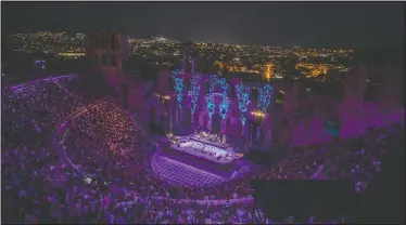  ??  ?? Spectators listen a concert at Odeon of Herodes Atticus as Athens is seen on the background July 15.