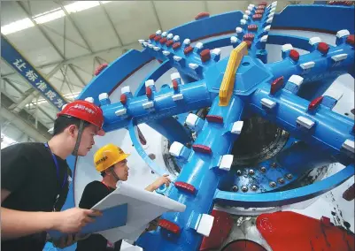  ?? PROVIDED TO CHINA DAILY ?? Two engineers from CRHIC check a railway tunnel-boring machine.