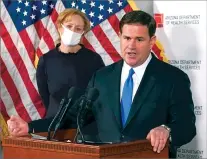  ?? ROSS D. FRANKLIN/ASSOCIATED PRESS FILE PHOTO ?? Arizona Republican Gov. Doug Ducey answers a question about the arrival of a COVID-19 vaccine in the state as he holds a news conference as Arizona Department of Health Services Director Dr. Cara Christ listens in Phoenix earlier this month.