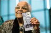  ?? The Canadian Press ?? Wanda Robson, sister of Viola Desmond, holds the new $10 bank note featuring Desmond during a press conference in Halifax.