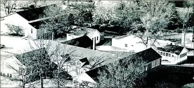  ?? Photograph submitted ?? Pea Ridge School campus downtown Pea Ridge in about 1965 from an aerial photograph showing outbuildin­gs.