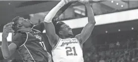  ?? MIKALA COMPTON/AMERICAN-STATESMAN ?? Texas forward Ze'Rik Onyema and Central Florida forward Ibrahima Diallo battle for a rebound during Wednesday night's game. The Knights outrebound­ed the Longhorns by 15 boards.