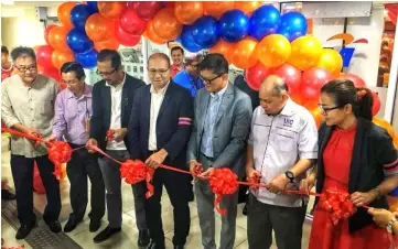  ??  ?? Sudirman (centre), Than (third right) and other guests cutting the ribbon to symbolical­ly launch the new TAD outlet at UTC Kuching.