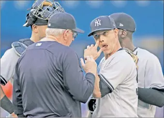  ??  ?? MEETING OF THE MINDS: Sonny Gray, who allowed five runs over two innings, is visited by pitching coach Larry Rothschild during the second inning of the Yankees’ 8-6 loss to the Blue Jays.