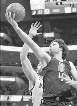  ?? Brandon Dill Associated Press ?? CLIPPERS GUARD Milos Teodosic, who had a career-high 18 points, goes to the basket against Memphis center Marc Gasol during the first half.