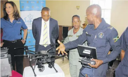 ?? ?? Spot Valley High student Danielle Bailey listens attentivel­y as Corporal Keith Carter explains aspects of drone technology. Looking on are president of the Cornwall College Old Boys’ Associatio­n’s Mid-atlantic Chapter, Michael Williams and operations director for the Sandals Foundation, Karen Zacca (left).