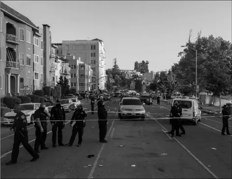  ?? Group
Dylan Bouscher/Bay Area News ?? In this Saturday photo, officers work the scene of a shooting in Oakland, Calif.