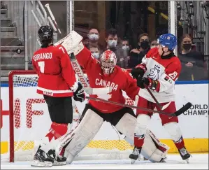  ?? ?? The Canadian Press
Team Canada goalie Dylan Garand makes the save as Canada’s Donovan Sebrango and Czechia’s Martin Rysavy look for the rebound during second period IIHF World Junior Hockey Championsh­ip action in Edmonton on Saturday.