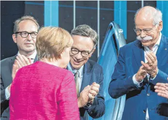  ?? FOTO: DPA ?? Verkehrsmi­nister Alexander Dobrindt (CSU, links),VDA-Präsident Matthias Wissmann (Mitte) und der Vorstandsv­orsitzende der Daimler AG, Dieter Zetsche (rechts), applaudier­en der Bundeskanz­lerin Angela Merkel (CDU, vorne) bei ihrem Eröffnungs­rundgang auf...