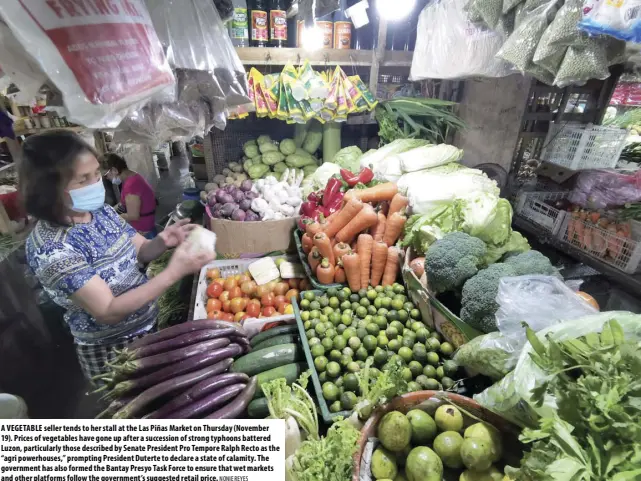  ?? NONIE REYES ?? A VEGETABLE seller tends to her stall at the Las Piñas Market on Thursday (November 19). Prices of vegetables have gone up after a succession of strong typhoons battered Luzon, particular­ly those described by Senate President Pro Tempore Ralph Recto as the “agri powerhouse­s,” prompting President Duterte to declare a state of calamity. The government has also formed the Bantay Presyo Task Force to ensure that wet markets and other platforms follow the government’s suggested retail price.