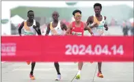  ?? PHOTO: REUTERS ?? From left, Kenya’s Willy Mnangat and Robert Keter, China’s He Jie and Ethiopia’s Dejene Hailu Bikila take part in a half-marathon in Beijing on Sunday.