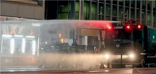  ??  ?? Riot police spray water against supporters of Brazil’s suspended President Dilma Rousseff as they attend a protest at Paulista avenue in Sao Paulo.