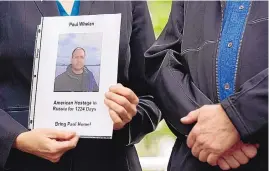  ?? PATRICK SEMANSKY/ASSOCIATED PRESS ?? Elizabeth Whelan, left, sister of U.S. Marine Corps vet and Russian prisoner Paul Whelan, holds a photo of her brother alongside the father of recently released Trevor Reed.