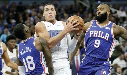  ?? JOHN RAOUX — THE ASSOCIATED PRESS ?? Orlando’s Aaron Gordon, center, runs into the Sixers’ Shake Milton, left, as Kyle O’Quinn helps on defense during the first half Wednesday night. Gordon was called for an offensive foul.