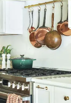  ?? ?? |TOP| Kara came across this vintage platter on a shopping trip and thought the colors in the scenery complement­ed the kitchen. “It’s like a little painting,” she says. Vintage ironstone is a smart way to organize utensils and add character to the kitchen.