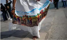  ?? ?? A woman on Lisbon’s Praça do Comércio shows the printed scene on her dress of slaves picking cotton. For about 400 years, slaves were brought from Africa to the Lisbon square where they were traded. Photograph: Armando França/AP