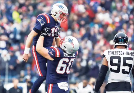  ?? Paul Connors / Associated Press ?? Patriots quarterbac­k Mac Jones is hoisted by center David Andrews (60) while celebratin­g after a touchdown during the first half against the Jaguars on Sunday.