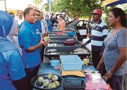  ??  ?? Barisan Nasional candidate for the Lumut parliament­ary and Pangkor state seats Datuk Seri Dr Zambry Abd Kadir greeting traders in Kampung Sitiawan, Manjung, yesterday.