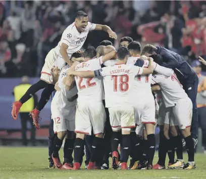  ??  ?? 2 Guido Pizarro of Sevilla celebrates with team mates after his dramatic equaliser against Liverpool in stoppage time.