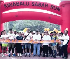  ?? ?? Father Terans Thaddeus of Sacred Heart Church (fourth from left), Sikh Gudwara Temple President Datuk Ram Singh (fifth left) and Lee Sze Meu of the Peak Nam Toong Temple cutting the ribbon to mark the official launch of the 5km and 10km Harmony Run/Walk in Kota Kinabalu.