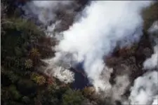  ?? CINDY ELLEN RUSSELL/HONOLULU STAR-ADVERTISER VIA AP ?? This Wednesday, May 9, 2018, photo shows an aerial view of the East Rift Zone, along which the Leilani Estates neighborho­od sits, from the ongoing Kilauea eruption, as seen from a helicopter flying around Pahoa, Hawaii. Hawaii County Civil Defense...
