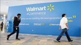  ?? Jeff Chiu Associated Press ?? WAL-MART has stores within 10 miles of 90% of the U.S. population, the retailer says. Above, workers in the lobby of the Walmart.com office in San Bruno, Calif.