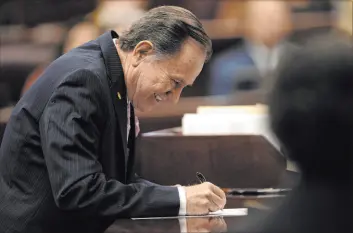  ?? Las Vegas Review-journal @ellenschmi­dttt ?? Ellen Schmidt
Assemblyma­n Richard Mcarthur, R-las Vegas, signs his oath of office on Feb. 6 in Carson City. He is proposing to limit the number of bills that can be introduced.