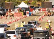  ?? Al Seib Los Angeles Times ?? VOLUNTEERS guide motorists arriving for selfadmini­stered tests for the novel coronaviru­s at the massive drive- through site at Dodger Stadium.