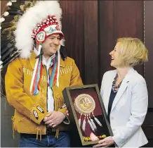  ?? IAN KUCERAK ?? Deputy Grand Chief Isaac Laboucan-Avirom and Premier Rachel Notley exchanged gifts Tuesday after Treaty 8 indigenous leaders signed an agreement with the province at the Alberta legislatur­e.